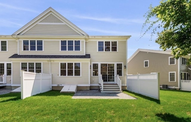 back of property featuring a lawn and central AC