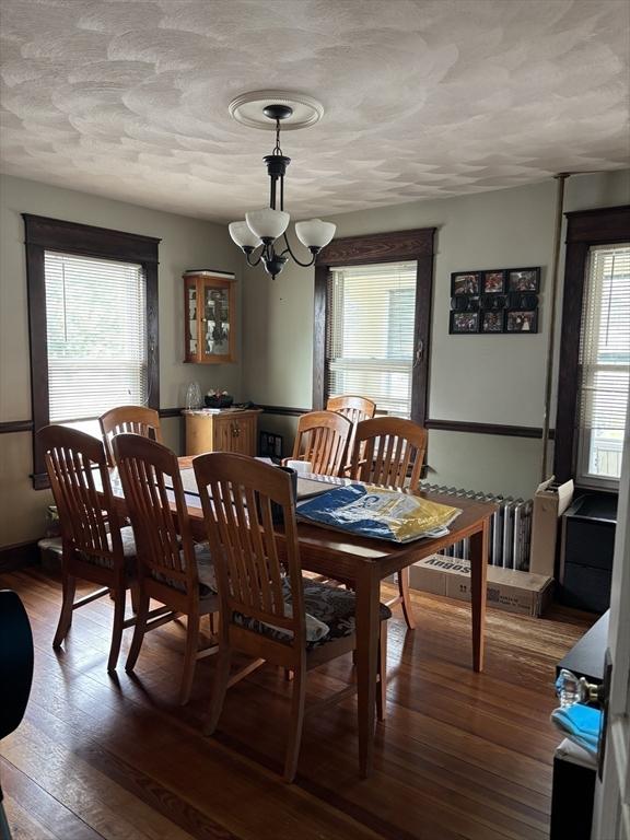 20 Osgood Ave, Lowell, MA 01850 - dining area featuring a chandelier, hardwood / wood-style flooring, radiator heating unit, and a textured ceiling