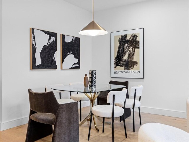 dining space with light wood-style floors and baseboards