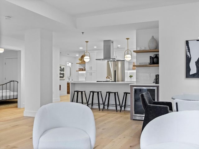 dining space with light wood-style flooring, recessed lighting, baseboards, and wine cooler