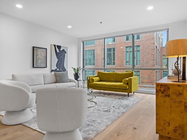 living room with recessed lighting, expansive windows, and wood finished floors