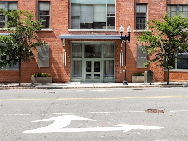 view of exterior entry with brick siding and french doors