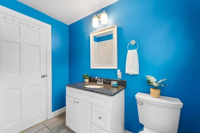 bathroom featuring toilet, baseboards, vanity, and tile patterned floors