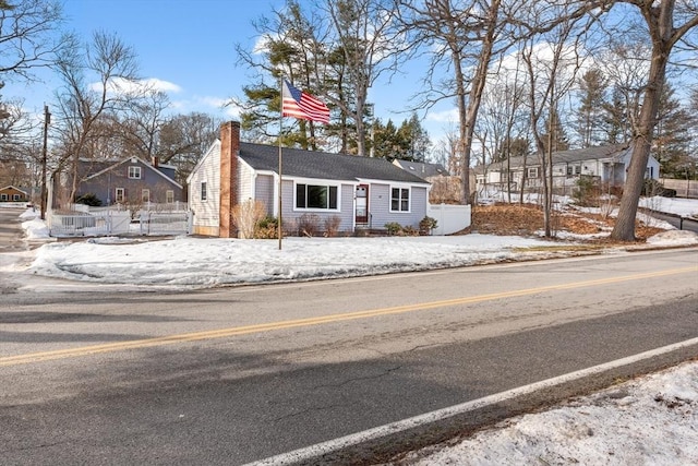 view of front of home featuring fence and a chimney