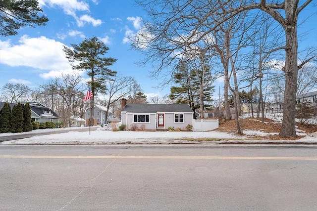 view of front of property featuring a chimney and fence