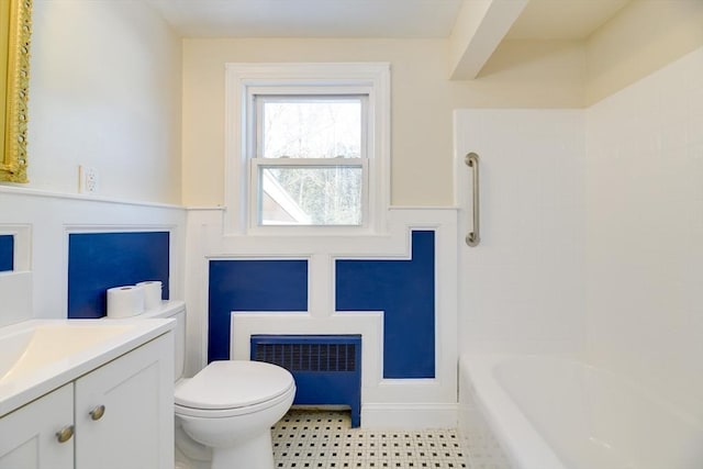 bathroom with toilet, radiator heating unit, vanity, and a wainscoted wall