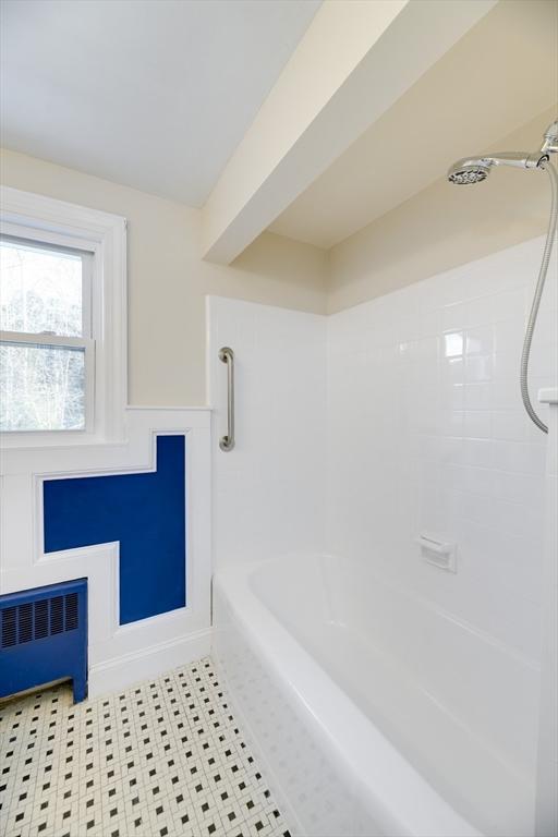 full bathroom featuring radiator and bathing tub / shower combination