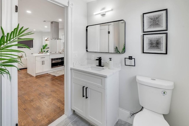 bathroom featuring hardwood / wood-style floors, vanity, and toilet