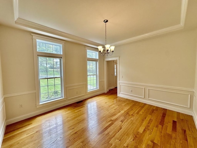 14 Pine Knoll Rd, Lexington, MA 02420 - unfurnished dining area featuring a raised ceiling, a chandelier, light wood-style flooring, a decorative wall, and a wainscoted wall