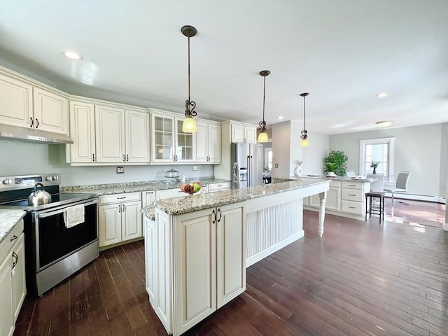 kitchen with recessed lighting, under cabinet range hood, dark wood-style flooring, glass insert cabinets, and appliances with stainless steel finishes