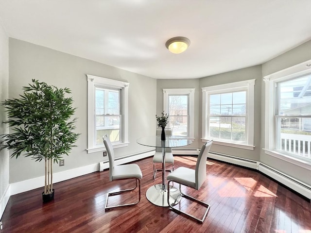 dining room with baseboards, plenty of natural light, and wood finished floors