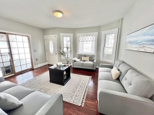living room featuring dark wood-type flooring, baseboards, and a baseboard radiator