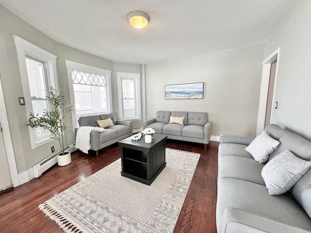 living area with dark wood-style flooring and baseboard heating