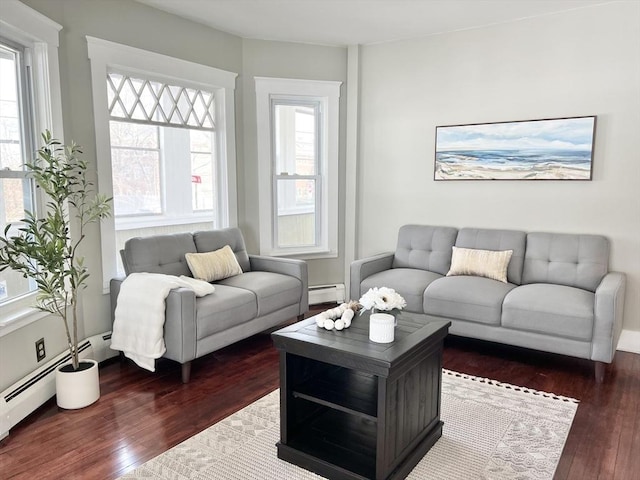 living room with dark wood-style flooring and a baseboard heating unit