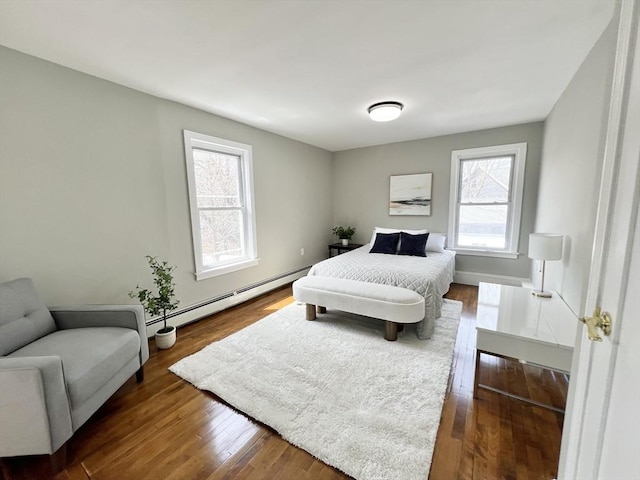 bedroom with a baseboard radiator, baseboards, and dark wood-style floors