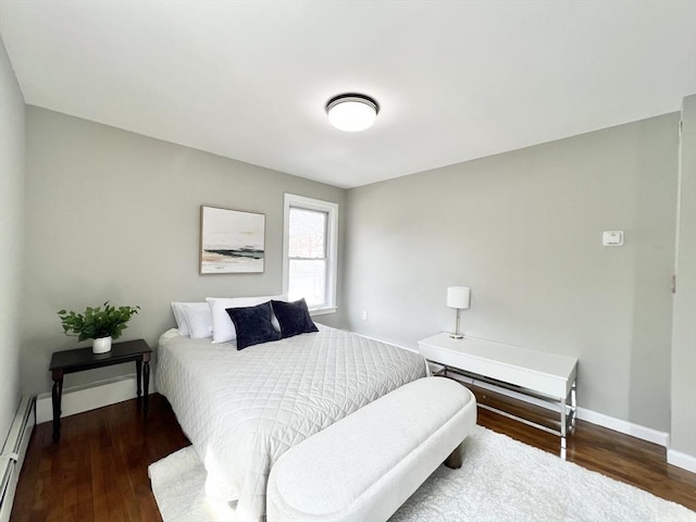 bedroom with baseboards, a baseboard radiator, and wood finished floors
