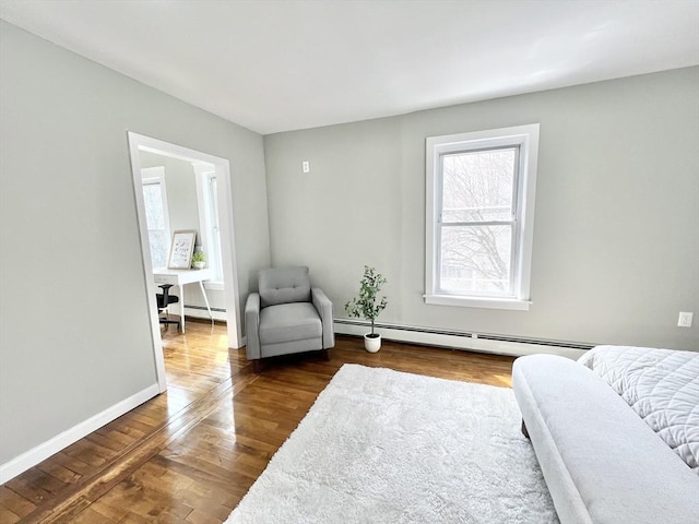 bedroom featuring baseboards, a baseboard radiator, and dark wood-style floors