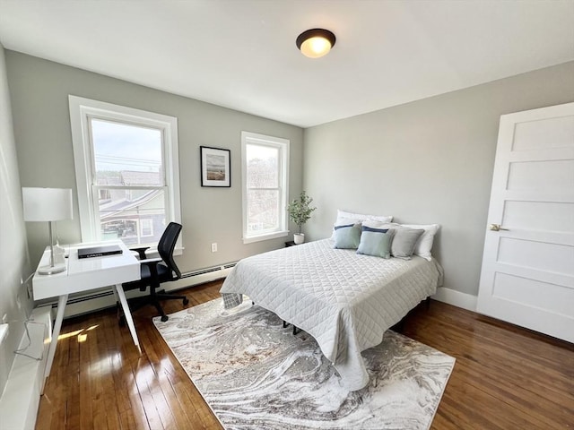 bedroom with a baseboard radiator, baseboards, and wood finished floors