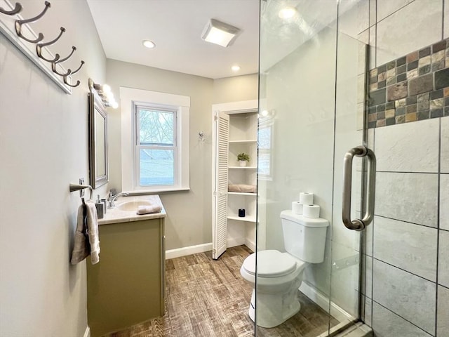 full bath featuring toilet, a stall shower, baseboards, vanity, and recessed lighting