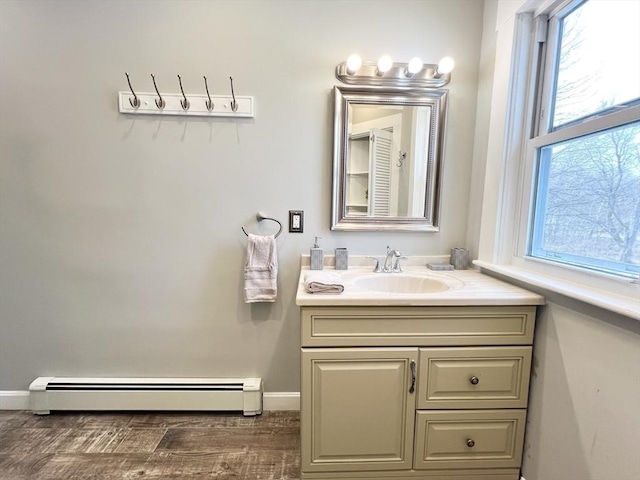 bathroom with vanity, baseboards, baseboard heating, and wood finished floors