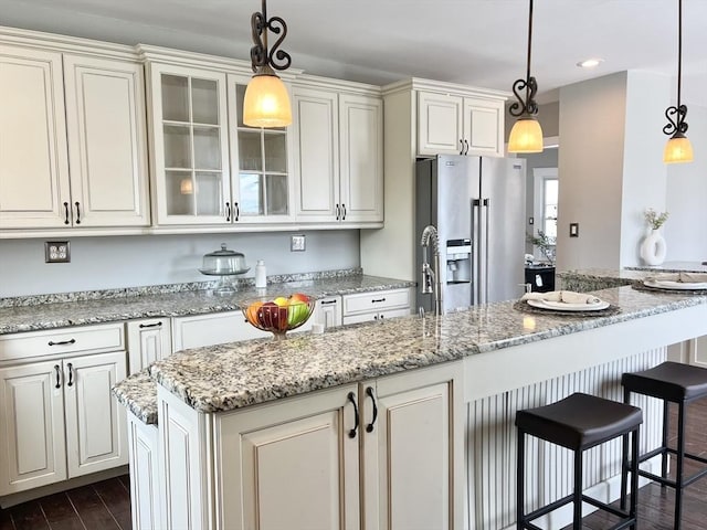 kitchen with recessed lighting, glass insert cabinets, decorative light fixtures, stainless steel refrigerator with ice dispenser, and dark wood-style floors