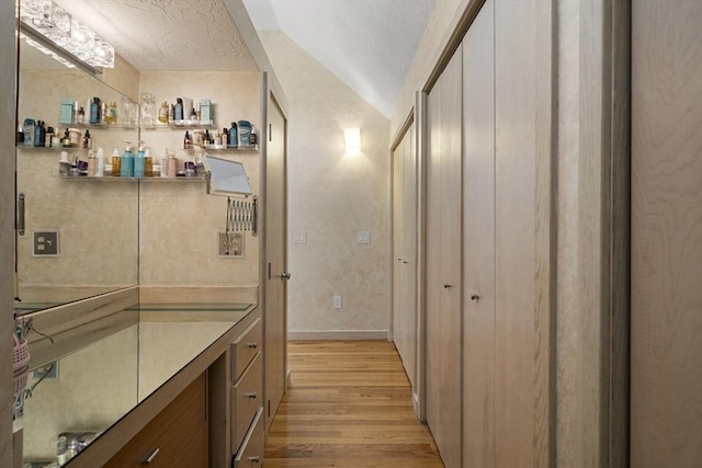 17 Juniper Ln, Framingham, MA 01701 - bathroom with wood finished floors, vaulted ceiling, baseboards, and a textured ceiling