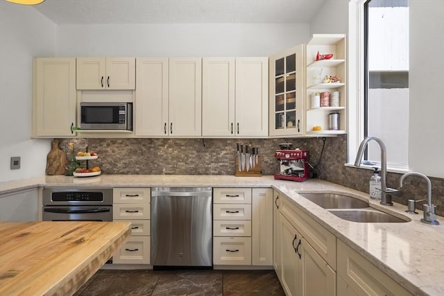 17 Juniper Ln, Framingham, MA 01701 - kitchen with stainless steel appliances, a sink, decorative backsplash, and light stone counters
