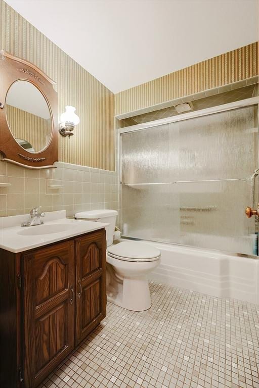 full bath featuring toilet, shower / bath combination with glass door, vanity, tile patterned floors, and wallpapered walls