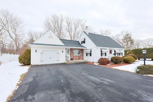 view of front of house featuring roof with shingles, a chimney, an attached garage, fence, and driveway