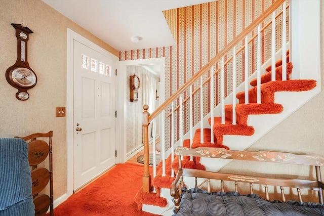 foyer entrance with carpet flooring, stairway, baseboards, and wallpapered walls