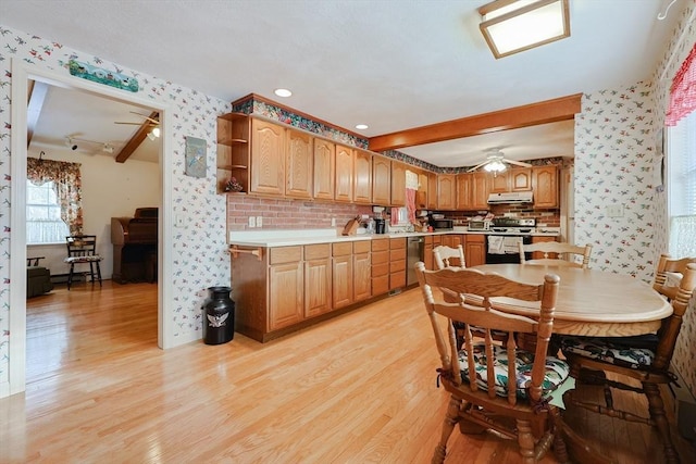 kitchen featuring open shelves, stainless steel appliances, light countertops, light wood-style flooring, and under cabinet range hood