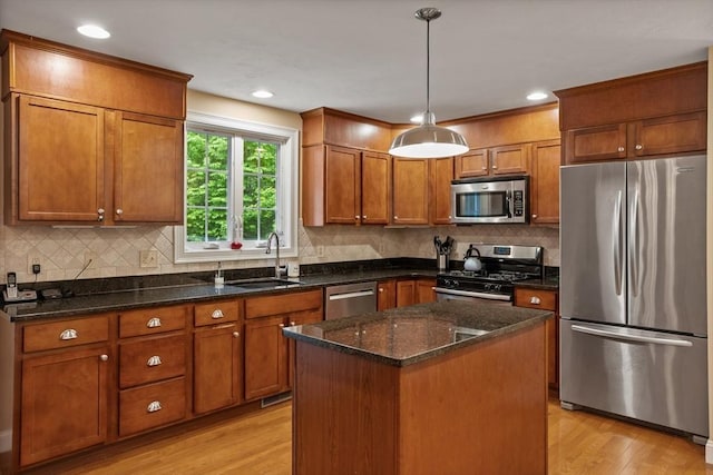 71 Fox Run Dr, Ayer, MA 01432 - kitchen with stainless steel appliances, light wood-style floors, a sink, brown cabinetry, and pendant lighting