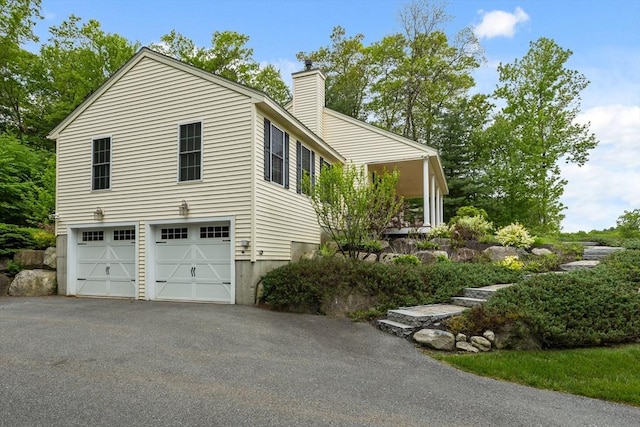 71 Fox Run Dr, Ayer, MA 01432 - view of property exterior with a chimney, driveway, and a garage