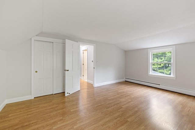 unfurnished room with vaulted ceiling, light wood-style flooring, baseboards, and baseboard heating