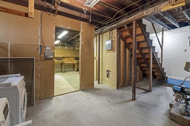 unfinished below grade area featuring independent washer and dryer, stairs, and electric panel