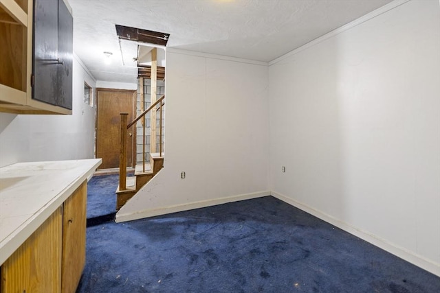 unfurnished living room featuring dark colored carpet, stairs, ornamental molding, and baseboards