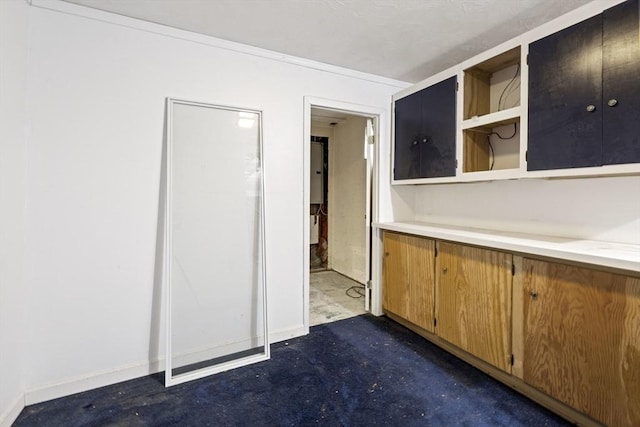 kitchen with light countertops, open shelves, concrete floors, baseboards, and brown cabinets
