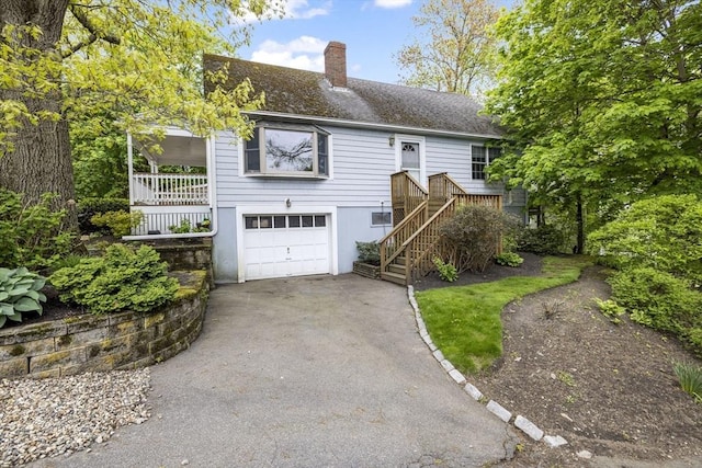 ranch-style house featuring an attached garage, asphalt driveway, a chimney, and a shingled roof