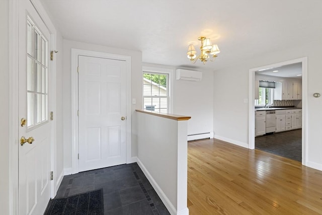 entryway with a wall mounted air conditioner, a chandelier, baseboard heating, and healthy amount of natural light