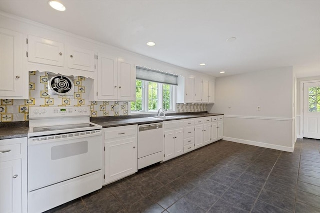 kitchen with white appliances, healthy amount of natural light, dark countertops, white cabinetry, and recessed lighting