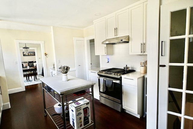 kitchen featuring gas range, under cabinet range hood, dark wood-style floors, and white cabinets