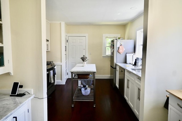kitchen featuring black range with gas stovetop, stainless steel dishwasher, light countertops, and white cabinetry