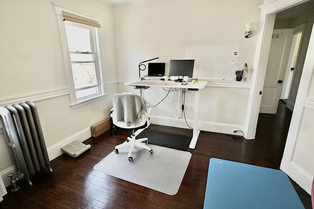 home office featuring radiator heating unit, wood finished floors, healthy amount of natural light, and baseboards