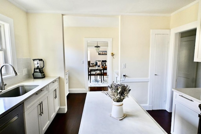 kitchen featuring black dishwasher, a sink, light countertops, white cabinetry, and dark wood finished floors