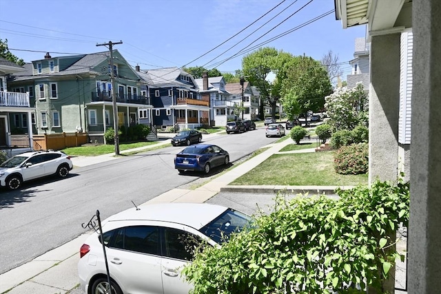 view of asphalt road featuring sidewalks, a residential view, and curbs
