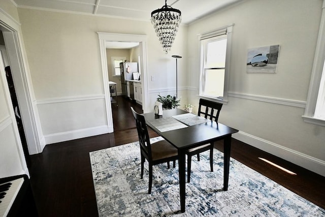 dining room with dark wood-style floors, a chandelier, and baseboards