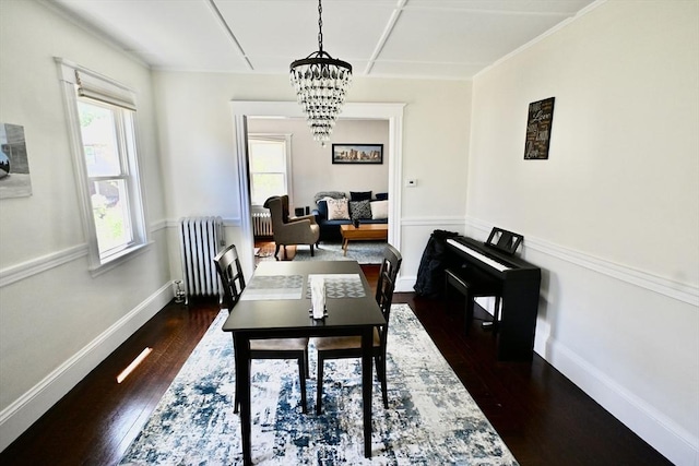 dining room featuring radiator heating unit, a chandelier, dark wood-style flooring, and baseboards