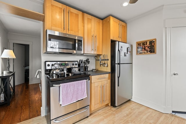 kitchen with appliances with stainless steel finishes, light brown cabinetry, ornamental molding, and light hardwood / wood-style floors