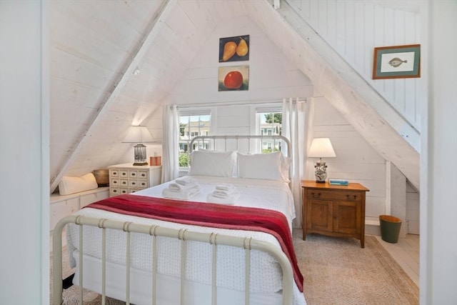 bedroom with vaulted ceiling and wood walls