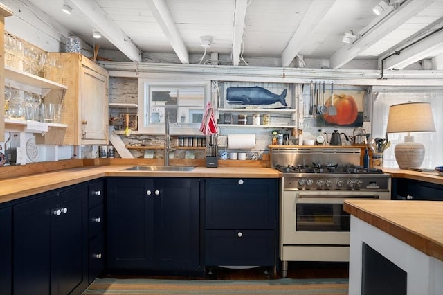 kitchen with high end stainless steel range oven, wooden counters, blue cabinets, and sink